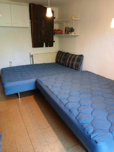 a large blue bed in a room at Schwalbennest am Lehmberg in Velgast