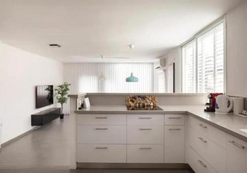 a kitchen with white cabinets and a large window at Oַ&O Group-Amazing APT Bat-Yam 3 Min Walk To Beach in Bat Yam