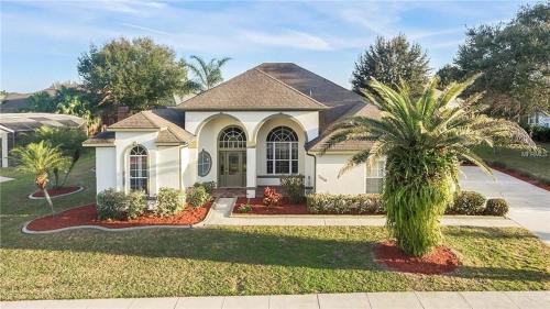 a house with a palm tree in the front yard at Formosa Villa with Private Pool & 5 Miles to Disney in Orlando