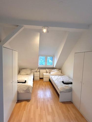 a attic bedroom with two beds and a window at Monteurs- und Ferienwohnung Miltenberg in Miltenberg