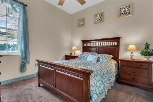 a bedroom with a wooden bed and a window at Formosa Villa with Private Pool & 5 Miles to Disney in Orlando