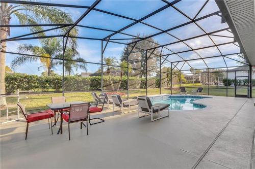 a patio with a table and chairs and a pool at Formosa Villa with Private Pool & 5 Miles to Disney in Orlando