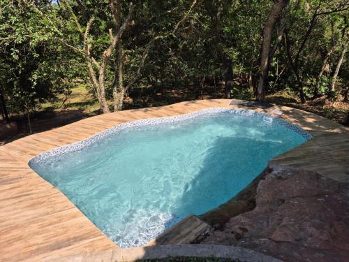a swimming pool with blue water on a wooden deck at Descanso Del Mbocayaty in Mbocayaty