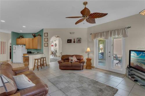 a living room with a couch and a ceiling fan at Formosa Villa with Private Pool & 5 Miles to Disney in Orlando