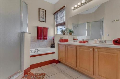 a bathroom with two sinks and a tub and a shower at Formosa Villa with Private Pool & 5 Miles to Disney in Orlando