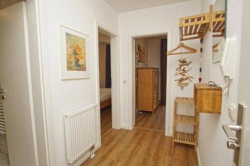 a hallway with white walls and wooden floors and a staircase at Ferienwohnung Neptun FeWo 01 - Terrasse, Garten in Drewoldke