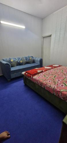 a room with a bed and a couch in it at AL Imran villa in Lahore