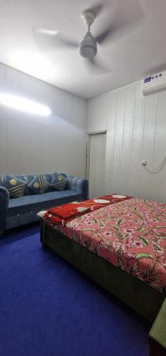 a room with a bed and a couch and a ceiling at AL Imran villa in Lahore