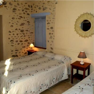 1 dormitorio con 1 cama, 2 lámparas y espejo en Hotel l'Oronge, en Saint-Jean-du-Gard