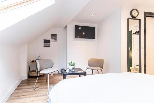 a bedroom with a bed and two chairs and a table at Lovely 2 Rooms Next to Sint-Niklaas Very Central in Ghent