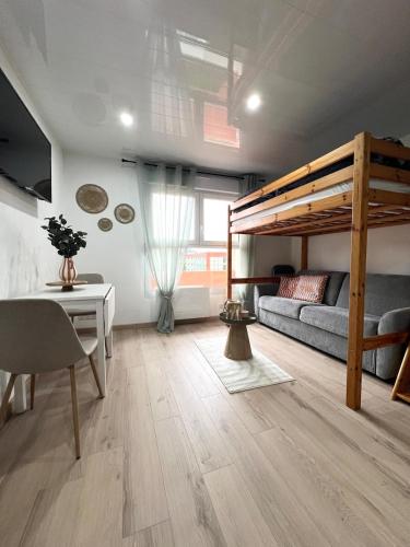 a living room with a loft bed and a desk at Le cosy du Futuroscope in Jaunay-Clan
