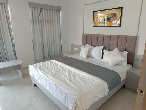 a bedroom with a large bed with white sheets and pillows at Hotel Royal Sky in Gandhinagar