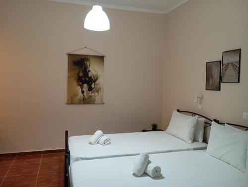 a room with two beds and a painting on the wall at Elenas Garden in Kavos