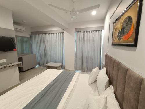 a bedroom with a large bed and a television at Hotel Royal Sky in Gandhinagar