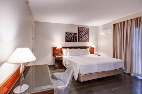 a hotel room with a bed and a lamp at Double Tree by Hilton São Paulo Itaim in Sao Paulo