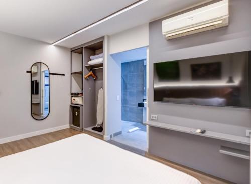 a living room with a tv and a bed at Double Tree by Hilton São Paulo Itaim in Sao Paulo