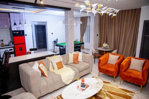 a living room with a couch and a pool table at WHITNEY LUXURY APARTMENTs in Lekki