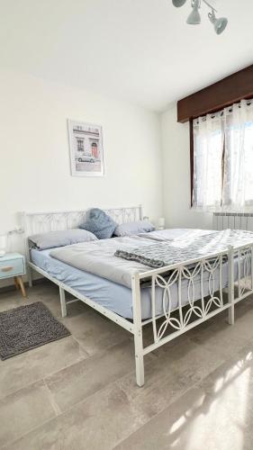 a white bed in a white room with a bed frame at Casa sul fiume in Gorgo