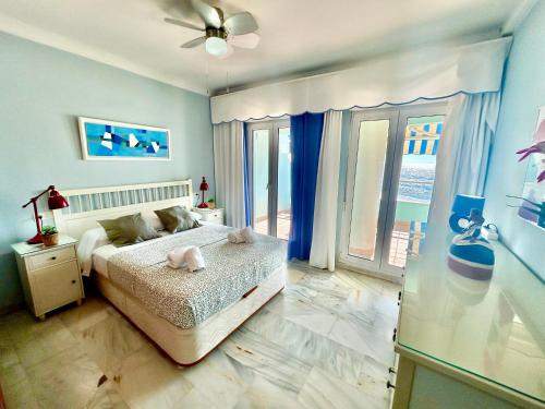 une chambre avec un lit et une grande fenêtre dans l'établissement GATU PREMIUM Villa Isabel TERRAZA,PARKING,1ºLINEA PLAYA,WIFI,VISTA AL MAR, à Cadix
