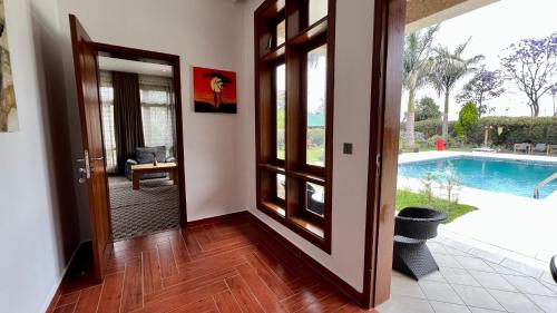 a hallway with a door leading to a swimming pool at Uyoga House in Arusha