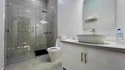 a bathroom with a toilet and a sink and a shower at Uyoga House in Arusha