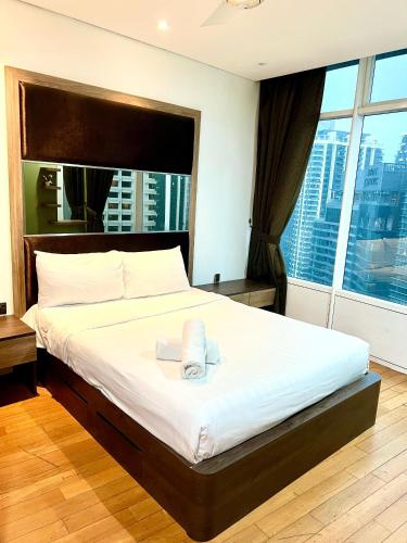 a bedroom with a large bed with a large window at Vortex Residenc klcc serviced apartment near by Bukit Bintang in Kuala Lumpur
