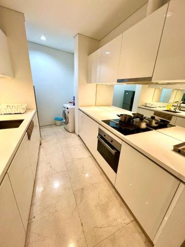a kitchen with white counters and a stove top oven at Vortex Residenc klcc serviced apartment near by Bukit Bintang in Kuala Lumpur