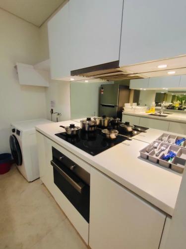 a kitchen with a stove with pots and pans on it at Vortex Residenc klcc serviced apartment near by Bukit Bintang in Kuala Lumpur