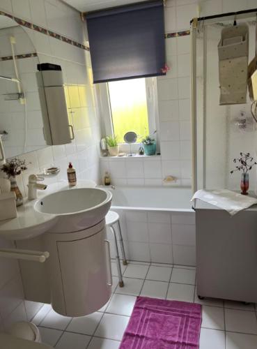 a bathroom with a tub and a sink and a toilet at Waldblick-Appartement in Baiersbronn
