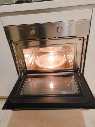 an oven with its door open in a kitchen at Vortex Residenc klcc serviced apartment near by Bukit Bintang in Kuala Lumpur