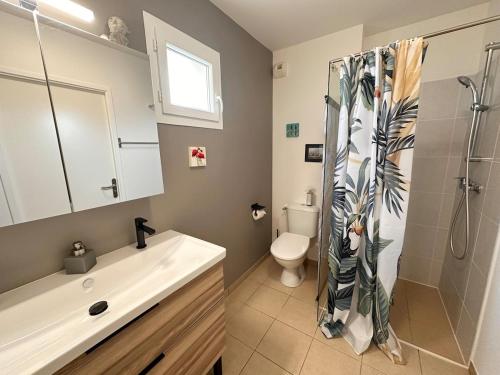a bathroom with a shower and a sink and a toilet at Un cocon de sérénité in Gujan-Mestras