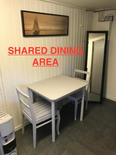 a white table and two chairs in a room at Private room with shared bathroom and kitchen in Ödkarby