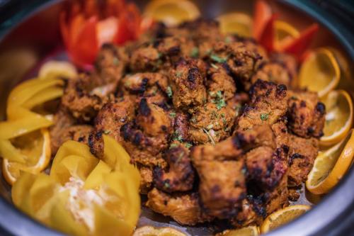 a bowl of food with meat and yellow peppers at Holiday Inn Dhaka City Centre by IHG in Dhaka
