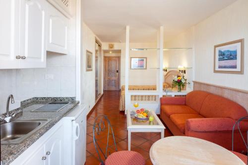 a kitchen and a living room with a couch at Apartamentos Masaru in Puerto de la Cruz