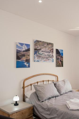 a bedroom with a bed and three pictures on the wall at Casa Piquita in Estreito da Calheta