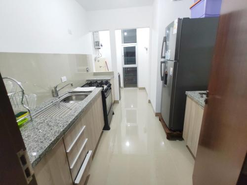 a kitchen with a sink and a refrigerator at Familiar, Fresco y Relax Atlantis in Santa Cruz de la Sierra