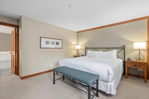 a bedroom with a white bed and a blue bench at Horstman House by Whistler Premier in Whistler