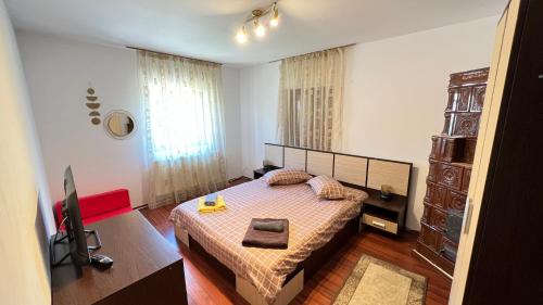a small bedroom with a bed and a television at Vila Natalie in Buşteni