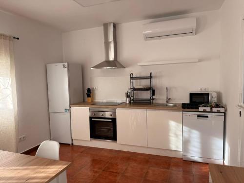 eine Küche mit weißen Schränken und einem Kühlschrank in der Unterkunft La Paca 