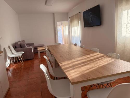 ein Esszimmer mit einem Holztisch und weißen Stühlen in der Unterkunft La Paca 