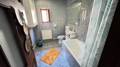 a bathroom with a tub and a toilet and a sink at Vila Natalie in Buşteni