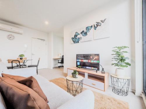 a living room with a couch and a tv at Stylish 1BR1BA apt in Footscray Pool Gym WIFI in Melbourne