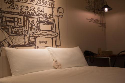 a bed with a drawing on the wall above it at Cho Hotel in Taipei