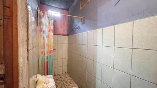 a bathroom with a shower with a tile wall at Casa AnaMar in Moyogalpa