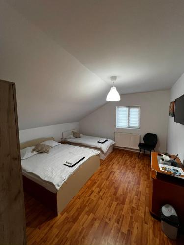 a room with two beds and a desk in it at Casa NIB Calimanesti in Călimăneşti