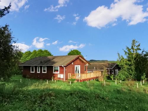 ein rotes Haus mitten auf einem Feld in der Unterkunft Lamastar in Woolfardisworthy