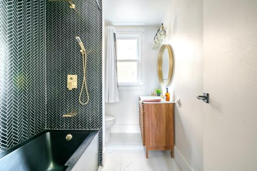 a bathroom with a black and white tiled wall at Prime Location Top Rated Clean Parking Free! in Columbus