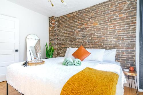 a bedroom with a large bed with a brick wall at Prime Location Top Rated Clean Parking Free! in Columbus
