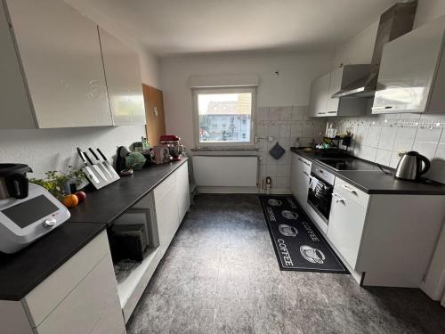 a small kitchen with white appliances and a window at Ferienwohnung mit Terrasse in Hofheim am Taunus