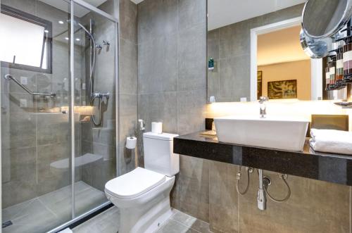 a bathroom with a toilet and a shower and a sink at Double Tree by Hilton São Paulo Itaim in Sao Paulo